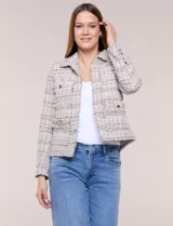 Chaqueta confeccionada en tejido de tweed beige con trama estructurada. Presenta cuello con solapa, frente abierto con botones metálicos y cuatro bolsillos funcionales. Las mangas largas de calce recto cuentan con bocamangas decoradas con botones y terminaciones deshilachadas al igual que los bordes.