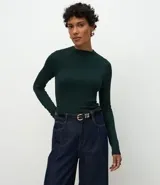 Blusa de manga larga confeccionada en viscosa acanalada, con cuello redondo y diseño de sisa raglán. Presenta un ajuste al cuerpo y textura acanalada.