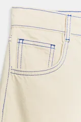 Jeans de tiro medio con cinco bolsillos, pernera holgada tipo barrel que se estrecha hacia el tobillo, y detalle de costuras a contraste. Cuenta con cierre frontal de cremallera y botón.