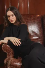 Sweater de tejido acanalado en color negro, con detalles de terminación en color bordó en el cuello, puños y ruedo. Presenta un diseño de corte clásico y manga larga.