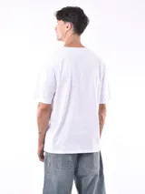 Remera de manga corta color beige, con corte oversize y cuello redondo.