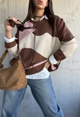 Sweater de punto con diseño de bloques de color en tonos chocolate, rosa y beige, de corte oversize y cuello redondo.