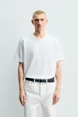 Camiseta regular fit de color beige, confeccionada en tejido de algodón compacto, con cuello redondo y manga corta.