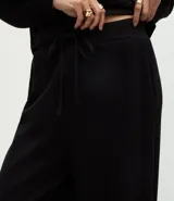 Pantalón de corte recto con cintura estructurada y lazo ajustable. Presenta un diseño básico y versátil con aberturas laterales en el ruedo.
