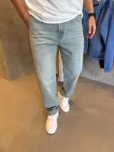 Jean de corte mom con efecto lavado claro y detalles de roturas sutiles en la parte frontal. Cuenta con cierre y botón metálico, bolsillos laterales y traseros.