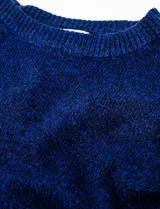 Buzo de tejido melange azul oscuro, con cuello redondo y mangas largas, corte cropped y calce holgado.