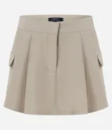 Short pollera beige de sarga con bolsillos cargo laterales y solapa, cintura ancha, pliegues delanteros y cierre frontal discreto.