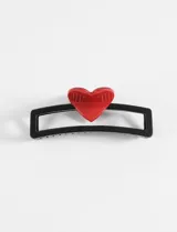 Broche para el pelo negro con un corazón rojo.