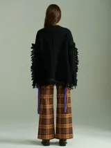 Sweater azul con bordado central en forma de trenza, detalles laterales a cuadros y terminaciones desflecadas. Tiene corte oversize, cuello redondo y tajos laterales con cordones.