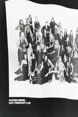 Remera negra de algodón con cuello redondo y mangas cortas. Estampado fotográfico en blanco y negro con texto Steven Meisel.