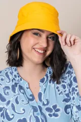Gorro tipo bucket color amarillo liso, con ala corta y costuras reforzadas.