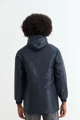 Campera de nylon color azul oscuro, con cierre frontal, capucha y bolsillos laterales con solapa. Presenta puños elásticos acanalados.