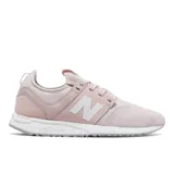 Championes New Balance modelo WRL247SCB para mujer, color rosado pálido, con capellada de malla y gamuza, logo "N" lateral en blanco y entresuela REVlite blanca.
