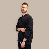 Buzo negro de corte oversize con efecto acid wash y bolsillos delanteros.