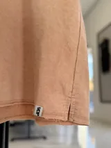 Remerón de corte oversize en tejido rústico con efecto gastado, cuello redondo y mangas cortas.
