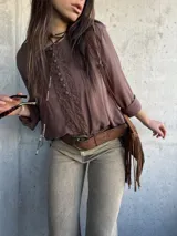 Blusa marrón chocolate de corte oversize, con mangas largas y detalles de encaje y botones forrados en el frente.