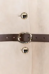 Blazer de cuello redondo y manga larga, confeccionado en tejido efecto ante. Presenta cierre frontal con botones, bolsillos con tapeta en el pecho y cinturón ajustable en la cintura.