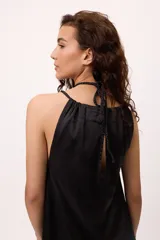 Vestido corto azul de satén con cuello halter y abertura en el pecho.