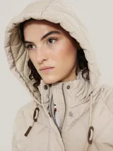 Campera acolchada color beige, con capucha y cierre de cremallera.
