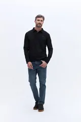 Remera polo de manga larga color negro, confeccionada en algodón. Presenta cuello clásico con cierre de botones y un pequeño logo bordado en el pecho.