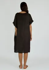 Vestido midi de lino color beige, con cuello en V, cierre frontal parcial con botones y mangas cortas con dobladillo.