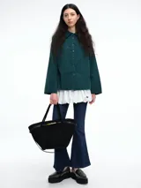 Camisa oversize de lyocell color tostado, con cuello clásico, cierre frontal de botones y mangas largas con puños anchos. Presenta un diseño de corte relajado con caída fluida.