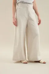 Pantalon largo de lino color tostado, tiro alto, corte ancho y recto, con costuras centrales decorativas y bolsillos laterales.