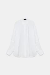 Camisa oversize de cuello solapa, manga larga con hombro caído y puños con pliegues. Presenta un bolsillo de plastrón en el frente, detalle de pinza con trabilla y botón en la espalda, bajo asimétrico y cierre frontal con botones.