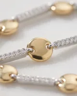 Pulsera de plata 925 con baño de oro, compuesta por una cadena de eslabones rectangulares pavimentados con circonias blancas, intercalados con discos dorados lisos.