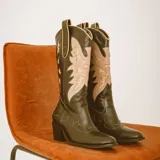 Botas tejanas de cuero negro con caña alta, taco cuadrado y delicadas costuras en contraste que forman diseños bordados en el cuerpo y empeine.