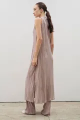 Vestido midi de diseño plisado en color rosado, con cuello alto y sin mangas. Presenta un tajo lateral y corte holgado, diseñado para ser usado en conjunto con pantalones del mismo tejido.
