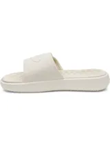 Chancletas Under Armour UA Ignite Pro 8 SL de color beige, con correa ajustable con acabado mate y forro de espuma suave. Cuenta con plantilla de espuma viscoelástica, laterales elevados para mayor estabilidad y suela de EVA con dibujo ranurado.