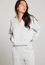 Buzo gris jaspeado de polar, con cuello en V y mangas largas.