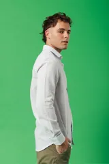 Camisa de manga larga para hombre, color azul claro jaspeado, con cuello clásico y botones blancos. Corte ajustado (slim fit).