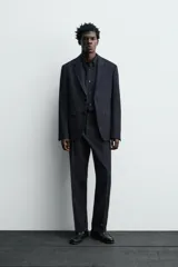Blazer de corte regular confeccionado en tejido de lana italiana. Presenta cuello con solapas de muesca, cierre frontal de un botón, bolsillos laterales con solapa y bolsillo de vivo en el pecho. Incluye aberturas en la espalda y forro interior.