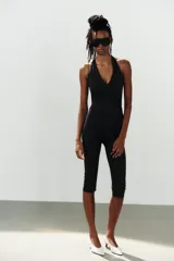 Mono de poliamida color negro con escote halter y escote en V profundo, de corte ajustado y largo por encima de la rodilla.