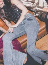 Jeans de corte flare y tiro medio, en color azul, con diseño acampanado y detalles de costuras en las piernas.