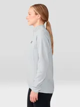 Buzo polar de mujer con cierre frontal de un cuarto, cuello alto y mangas raglán. Presenta un diseño minimalista en color gris claro con el logo de la marca bordado en el pecho.