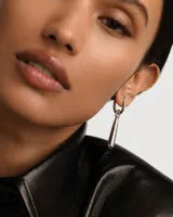 Aro individual de plata con colgante en forma de gota.