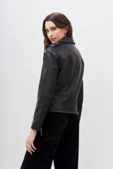 Campera de cuero ovino estilo motoquera, con solapas, charreteras en los hombros y cierres metálicos plateados en el frente, bolsillos y puños. Cuenta con forro interior de poliéster.