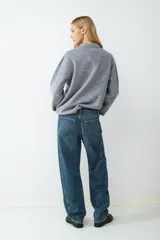 Jeans de tiro medio con corte barrel y ajuste relajado, diseño clásico de cinco bolsillos, cierre frontal de cremallera y botón metálico.
