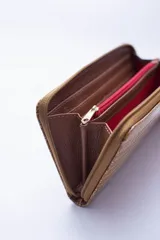 Billetera rectangular con cierre perimetral, confeccionada en cuero con textura de reptil. Cuenta con múltiples compartimentos internos para tarjetas, documentos y billetes, además de un bolsillo interior con cierre para monedas.