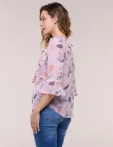 Blusa de gasa rosada con estampado floral, escote en V con volados en cascada en la pechera y mangas tres cuartos acampanadas.