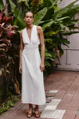 Vestido midi de algodón con diseño de bordado inglés perforado. Presenta escote en pico, diseño sin mangas y tirantes cruzados en la espalda con detalle de argolla.