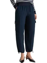 Pantalón tipo jogger cargo de Tommy Hilfiger, color azul marino, con cintura elástica, bolsillos laterales tipo cargo con solapa y botones, y ruedos ajustables con cordón.