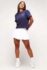 Remera blanca de algodón con corte crop, mangas cortas y estampado frontal con texto y logo en color gris.