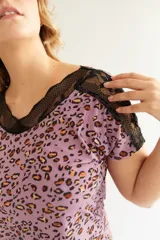 Conjunto de pijama color rosa con estampado de leopardos, detalles de encaje rojo en el escote y mangas de la remera y en el ruedo del short.