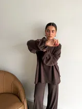 Canguro de tejido acanalado color bordó, con capucha, mangas largas abullonadas y corte holgado.