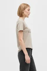 Remera negra de algodón, con cuello en V, mangas cortas, corte al cuerpo y estampa frontal con la frase "Emotionally Unavailable" en letras rosadas.