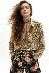 Camisa de terciopelo con estampado floral en tonos mostaza, cuello camisero clásico, cierre frontal con botones y mangas largas.